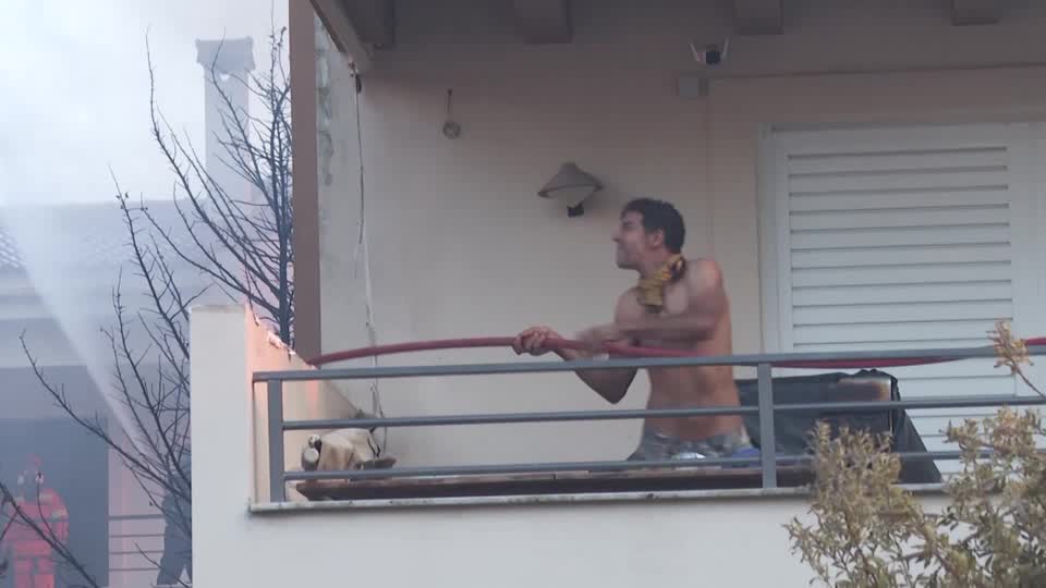 Greek residents defend homes as wildfire tears through village